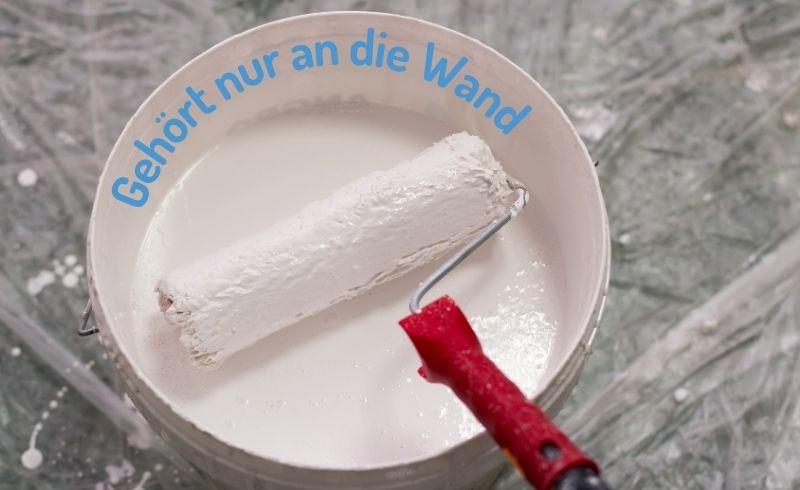 Eimer mit Wandfarbe und Farbrolle. Darüber steht: Gehört nur an die Wand